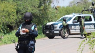 Policías resguarda un vehículo que fue atacado.