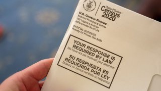 Close-up of human hand holding a letter from the Census Bureau