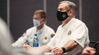 Gobernador Greg Abbott y Nim Kidd usando mascarillas.