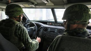 Soldados a bordo de unidad militar.