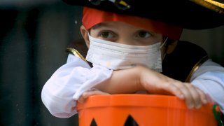A child in pirate costume with a cloth mask