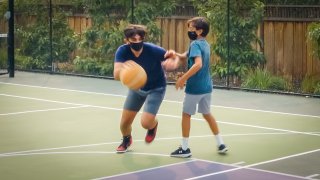 two teens playing basketball