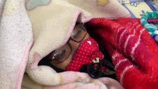 woman bundled to stay warm in cold inside her home