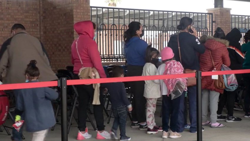 Migrantes esperando en fila.