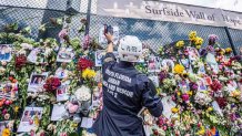 A rescuer visits the 'Surfside Wall of Hope & Memorial' near the partially collapsed 12-story Champlain Towers South condo building in Surfside, Florida, on July 2, 2021. - Two more victims were found in the rubble of a collapsed apartment building in Florida, including the body of a seven-year-old girl, bringing the death toll from last week's tragedy to 20, with 128 people still unaccounted for, officials said on July 2, 2021. (Photo by Giorgio Viera / AFP) (Photo by GIORGIO VIERA/AFP via Getty Images)