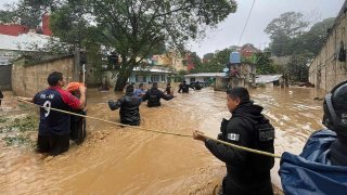 Hombres caminan por una calle inundada