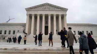 La gente espera en fila para escuchar los argumentos orales en la Corte Suprema de Estados Unidos mientras otros se reúnen para mostrar su apoyo al plan de alivio de la deuda estudiantil.