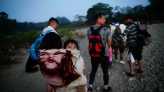 Adultos y niños migrantes hacen fila en la comunidad de Bajo Chiquito para ser trasladados a la Estación de Recepción Migratoria (ERM) de San Vicente, en Metetí (Panamá), en una fotografía de archivo.