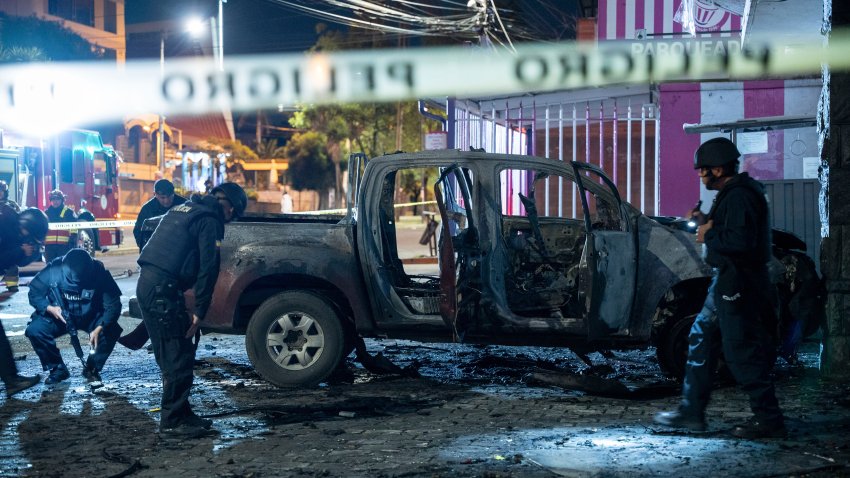 La policía inspecciona una camioneta que explotó afuera de una oficina utilizada por el Servicio Nacional de Atención a Personas Privadas de Libertad que administra el sistema penitenciario en Quito, Ecuador, la madrugada del jueves 31 de agosto de 2023. (AP Foto/Carlos Noriega)