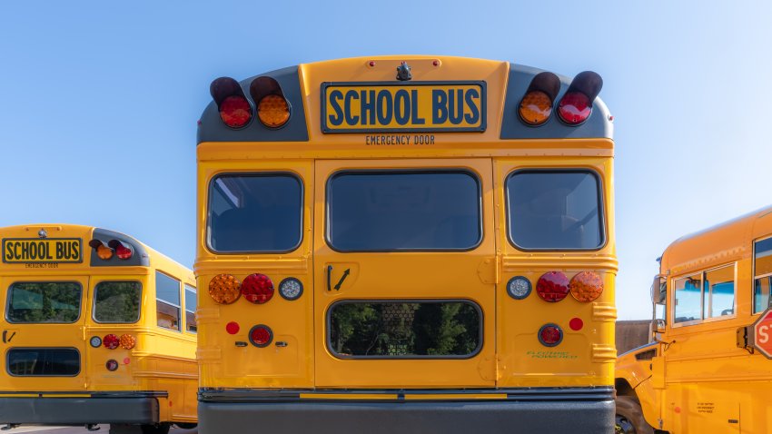 Rear of a parked yellow electric school bus at a charging station