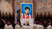 ASSISI, ITALY – OCTOBER 10: A tapestry  featuring a portrait of Carlo Acutis is hang at the St. Francis Basilica during the beatification ceremony of Carlo Acutis, on October 10, 2020 in Assisi, Italy. The fifteen-year-old Carlo Acutis member of the Millennial generation who died on 12 October 2006 from M3 fulminant leukemia, is considered a “computer geek” on  of his ion and skill with computers and the internet. Acutis applied himself to creating a website dedicated to cataloguing each reported Eucharistic miracle in the world. (Photo by Vatican Pool/Getty Images)