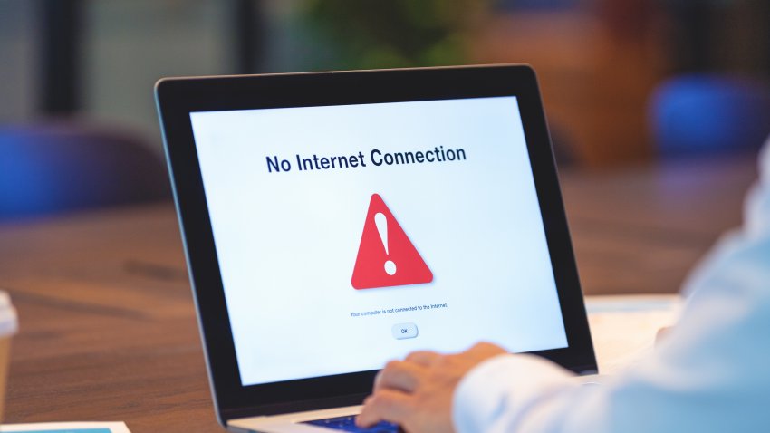 Businessman looking at an internet failure screen on a computer. He is in an office