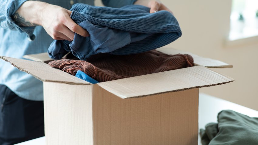 Volunteer with donation box with clothes