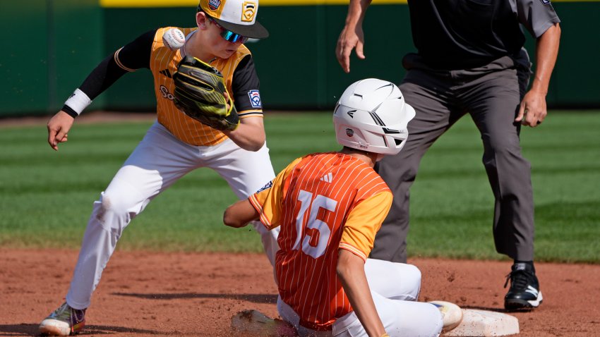 Boerne, Texas’ Julian Hurst (15) steals second on a wild pitch as the ball gets away from Lake Mary, Fla.’s Chase Anderson, left, during the first inning of the United State Championship baseball game at the Little League World Series tournament in South Williamsport, Pa., Saturday, Aug. 24, 2024. (AP Photo/Tom E. Puskar)