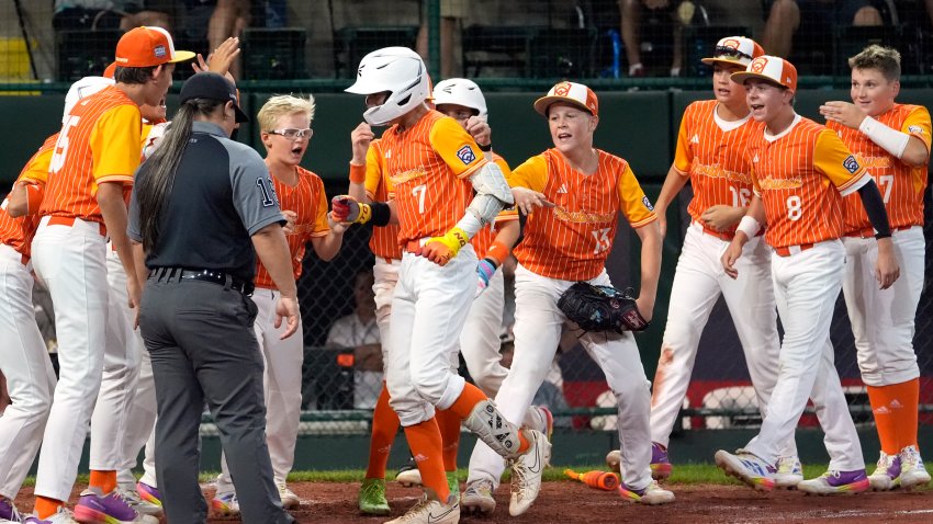 Boerne, Texas’ Doc Mogford (7) is greeted at home plate by his teammates after his home run against Newtown, Pa. during the fifth inning of a baseball game at the Little League World Series tournament in South Williamsport, Pa., Thursday, Aug. 15, 2024. (AP Photo/Tom E. Puskar)