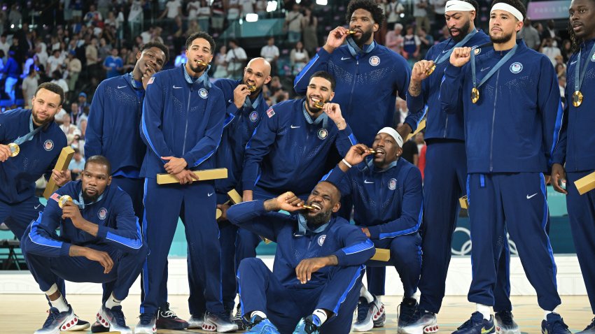 TOPSHOT – Gold medallists (From L) USA’s #04 Stephen Curry, USA’s #07 Kevin Durant, USA’s #05 Anthony Edwards, USA’s #09 Tyrese Haliburton, USA’s #08 Derrick White, USA’s #10 Jayson Tatum, USA’s #06 LeBron James, USA’s #11 Joel Embiid, USA’s #13 Bam Adebayo, USA’s #14 Anthony Davis, USA’s #15 Devin Booker and USA’s #12 Jrue Holiday pose on the podium after the men’s Gold Medal basketball match between France and USA during the Paris 2024 Olympic Games at the Bercy  Arena in Paris on August 10, 2024. (Photo by Damien MEYER / AFP) (Photo by DAMIEN MEYER/AFP via Getty Images)