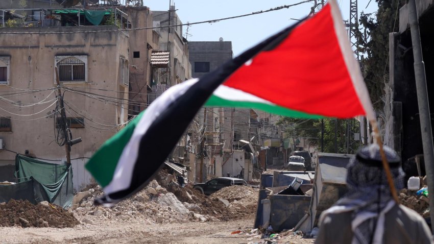 Un hombre sostiene una bandera palestina mientras soldados israelÌes realizan una operaciÛn en el campo de refugiados de Tulkarem, cerca de la ciudad cisjordana de Tulkarem, este miÈrcoles. Al menos dos palestinos murieron el 10 de septiembre durante las operaciones militares israelÌes en Tulkarem y su campo de refugiados, seg˙n el Ministerio de Salud palestino. EFE/ Alaa Badarneh