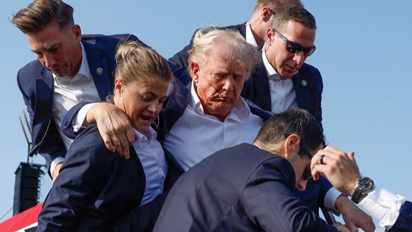 BUTLER, PENNSYLVANIA – JULY 13: Republican presidential candidate former President Donald Trump is rushed offstage by U.S. Secret Service agents after being grazed by a bullet during a rally on July 13, 2024 in Butler, Pennsylvania. Butler County district attorney Richard Goldinger said the shooter is dead after injuring former U.S. President Donald Trump, killing one audience member and injuring another in the shooting. (Photo by Anna Moneymaker/Getty Images)