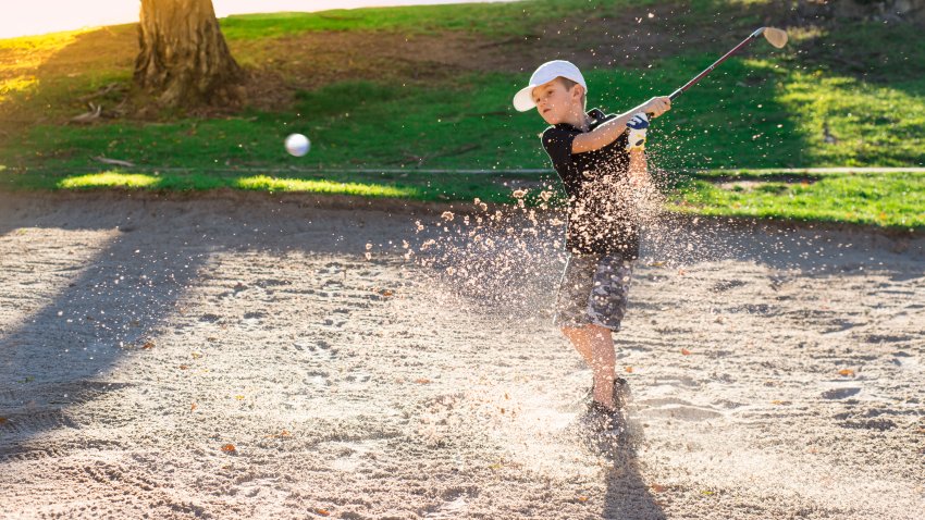 Boy Golfer Hitting Out A Sand Bunker