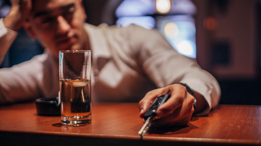 One drunk man sitting at bar counter, holding car keys.