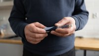 Close-up of man making insulin injection in belly  with insulin pen