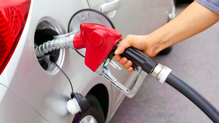 Woman filling car with leaded fuel in garage