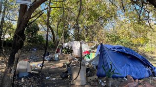 Se colgaron carteles de "prohibido el paso" en un campamento para personas sin hogar en el vecindario de Lykins el 1 de noviembre de 2024.