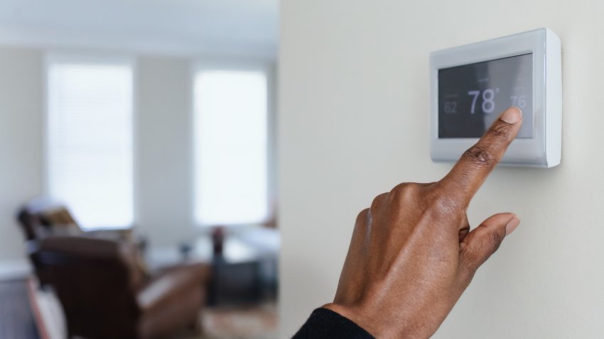 Close-up of unrecognizable black woman adjusting thermostat