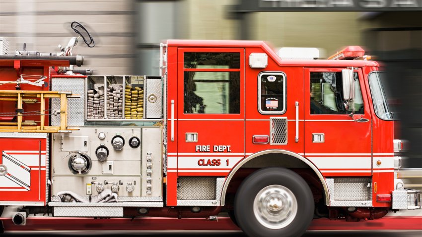 Blurred view of fire truck driving in city