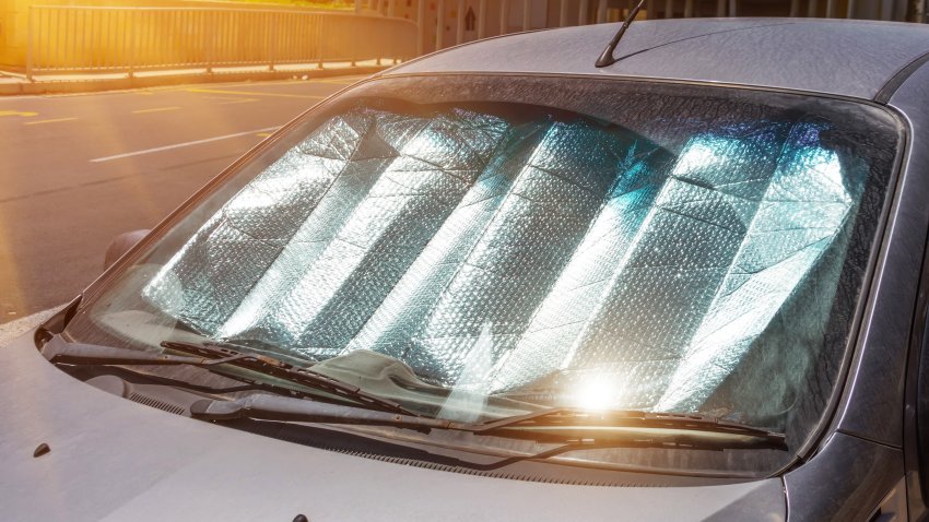 Protective reflective surface under the windshield of the passenger car parked on a hot day, heated by the sun’s rays inside the car
