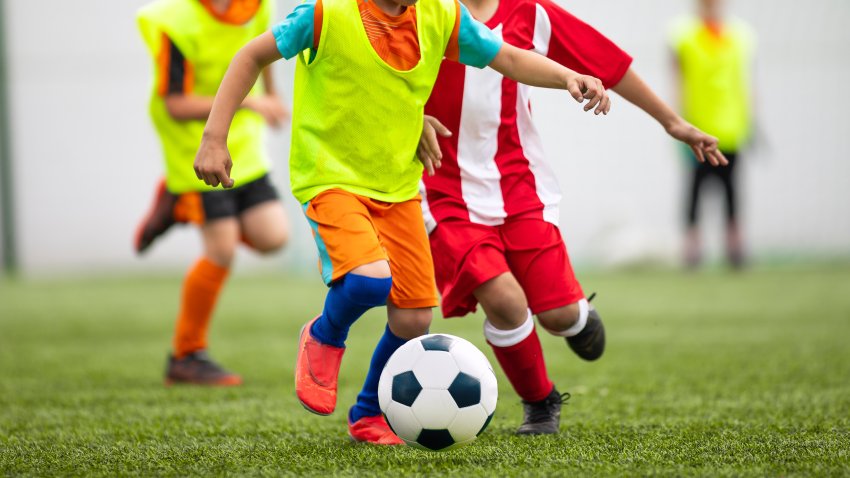 Football soccer match for children. Kids in opposite teams playing soccer game in summer tournament. School Soccer football league
