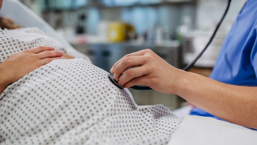 Doctor using stethoscope to listing baby’s heartbeat, heart of fetus. Gynaecologist examining pregnant woman, baby’s health  and well-being during pregnancy. Non-invasive method.