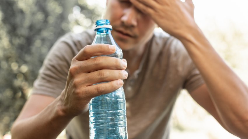 Person drinks from bottle water replenish fluids.
