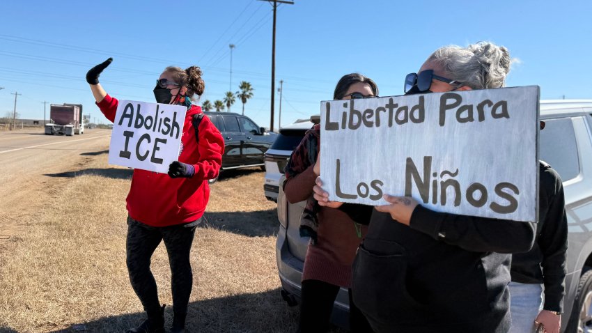 People hold anti-ICE signs as they gather during a demonstration and vigil outside the South Texas Family Residential Center in Dilley, Texas, on January 28, 2026. Five-year-old Liam Conejo Ramos and his father, Adrian Conejo Arias, asylum seekers from Ecuador who were arrested on January 20 in Minneapolis by ICE agents, are being held at the center along with others detained by ICE. US President Donald Trump said on January 27 that he would "de-escalate a little bit" in Minneapolis after the fatal shootings of two civilians fueled a storm of criticism over his signature immigration crackdown. (Photo by Moisés ÁVILA / AFP via Getty Images)
